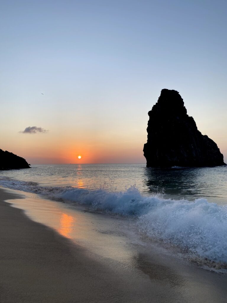 Vista da Praia Cacimba do Padre durante o pôr-do-sol no fim da tarde com maré agitada - Quanto custa viajar para Fernando de Noronha