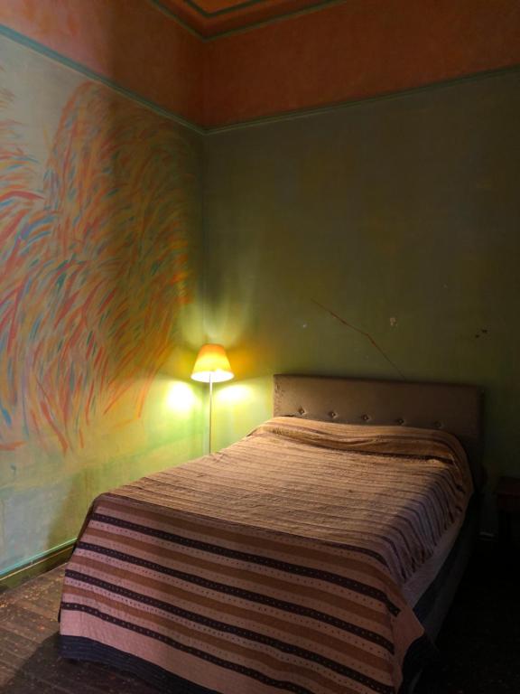 Quarto em apartamento histórico elegante no Parque Rodó, com cama de casal e abajur, uma ótima opção de onde ficar em Montevidéu no Uruguai