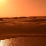 Vista dos Lençóis Maranhenses durante o fim da tarde com seu curso de água