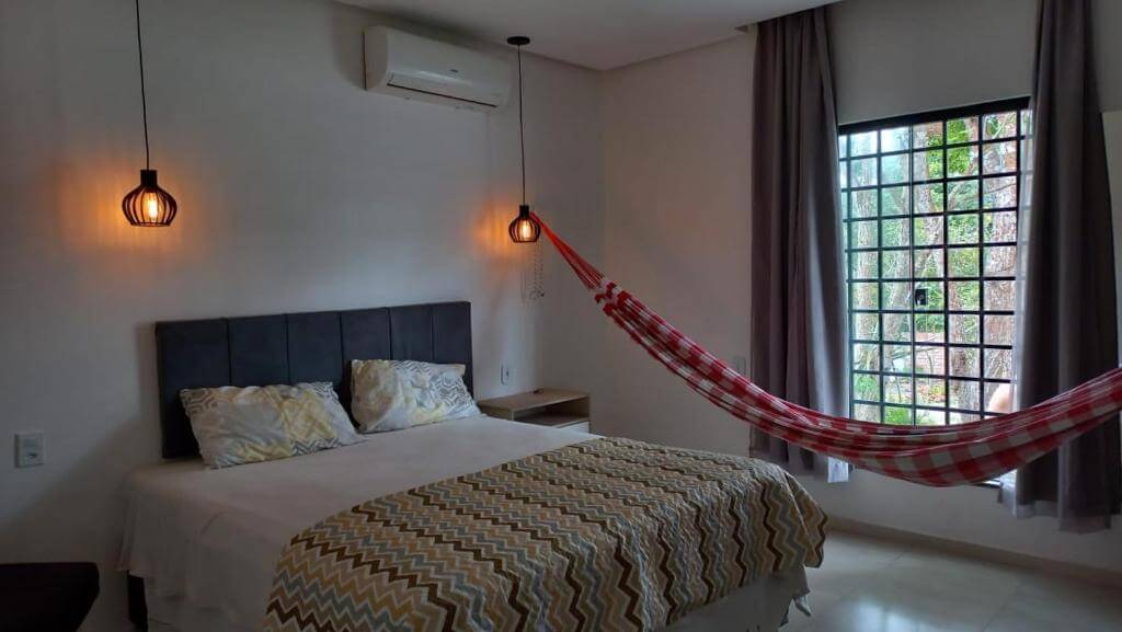 Quarto de casal da casa confortável com 4 quartos, em Alter do Chão no Pará, com rede, ar-condicionado, quarto de casal e cortinas na janela
