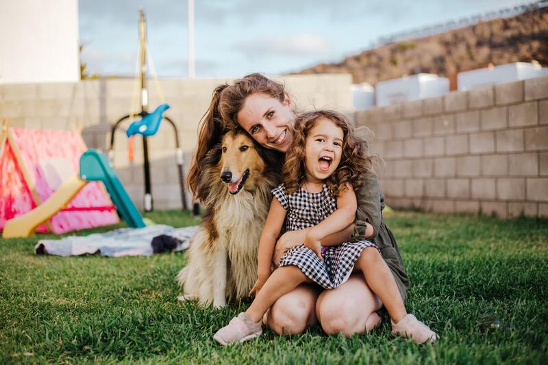 Hoteis Pet Friendly em Monte Verde - MG - Uma mulher adulta e uma criança sorrindo com um cachorro de estimação do lado esquerdo