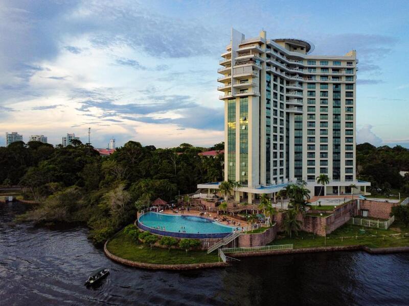 Fachada do Hotel Tropical Executive mostrando o prédio e a piscina durante o dia