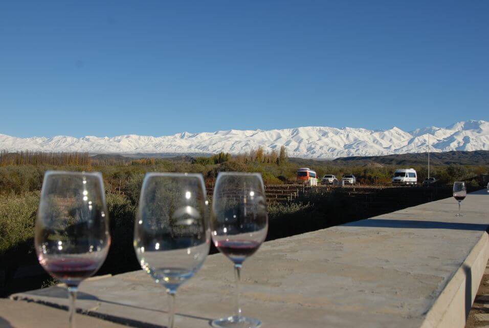 Taças de vinho em primeiro plano e a fundo um monte de gelo em Mendoza na Argentina