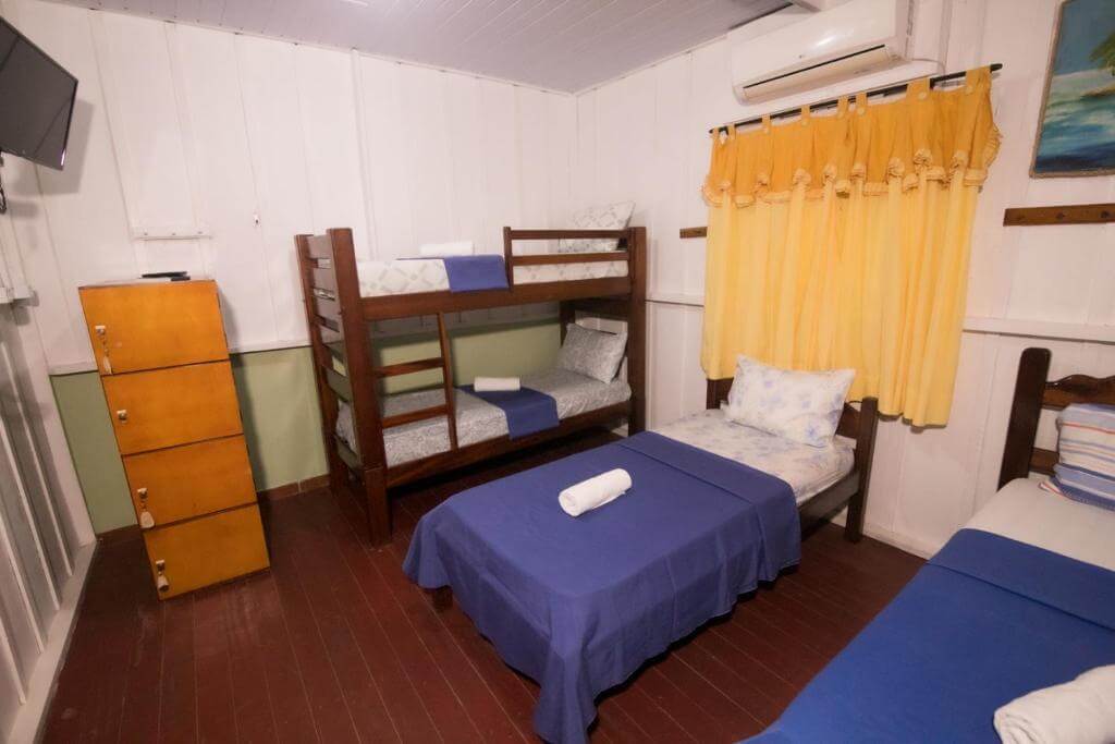 Quarto da Pousada Hostel Coração Verde, em Alter do Chão no Pará, com camas de solteiro, beliche, ar-condicionado, televisão de tela plana e armário