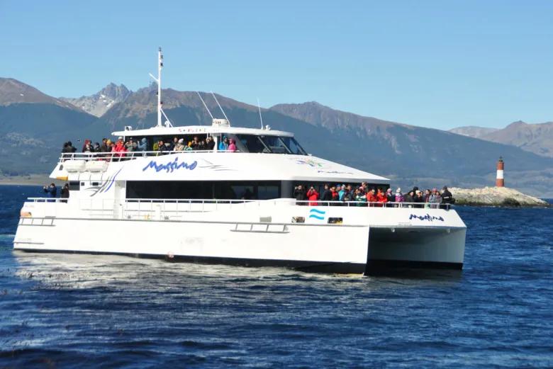 Passeio de barco no canal beagle em Ushuaia na Argentina, com muitas pessoas embarcando durante um dia de sol