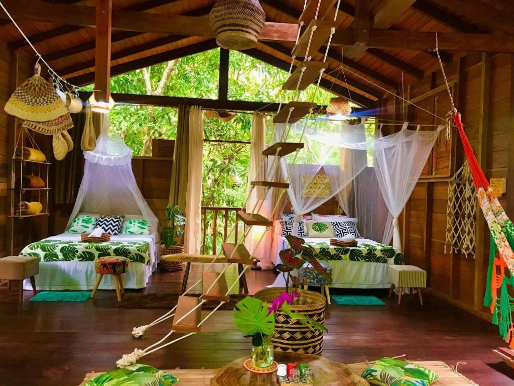 Quartos com cama de casal, travesseiros e mosqueteiros, além de rede e toda a decoração na Casa da Árvore em Alter do Chão no Pará