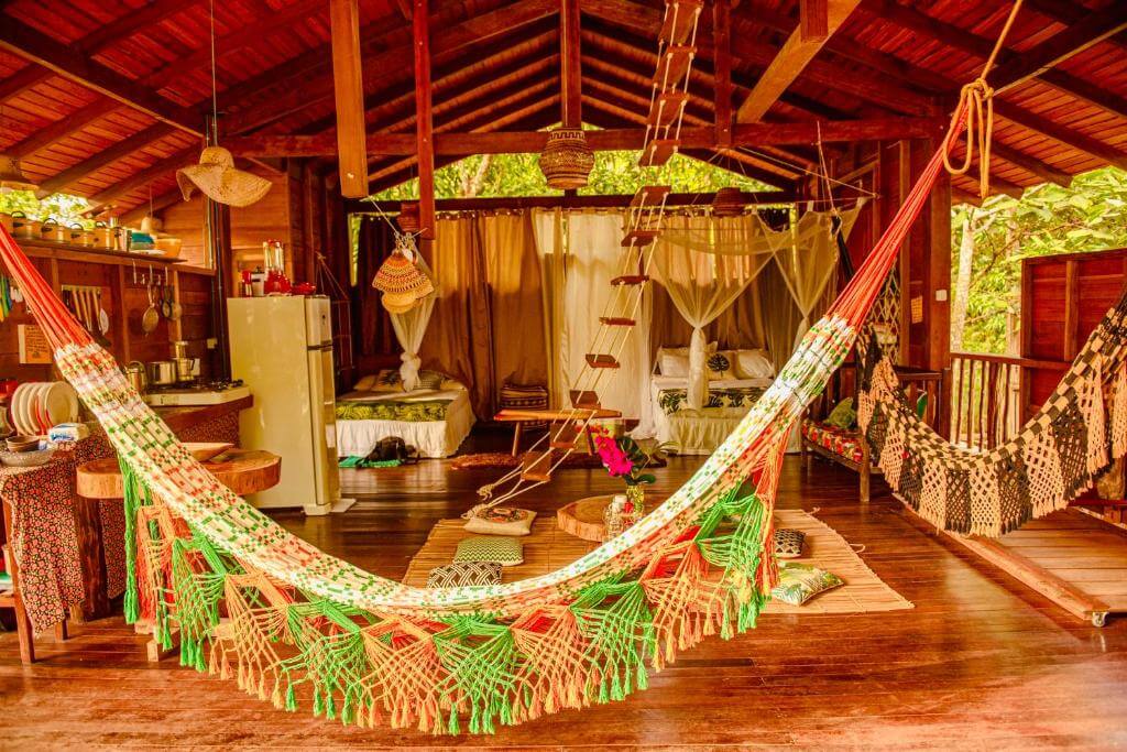 Cômodo da Casa da Árvore em Alter do Chão no Pará com cozinhas, camas, redes e travesseiros