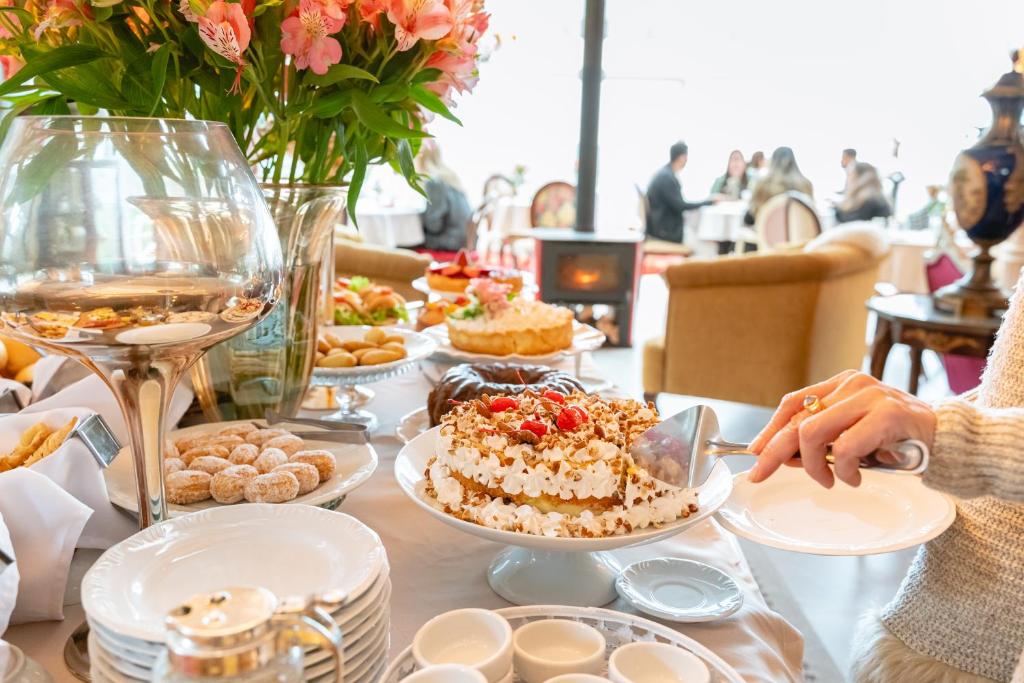 Destaque de uma mesa de café da manhã, com bolos e biscoitos, no Le Boutique Hotel Gramado. 