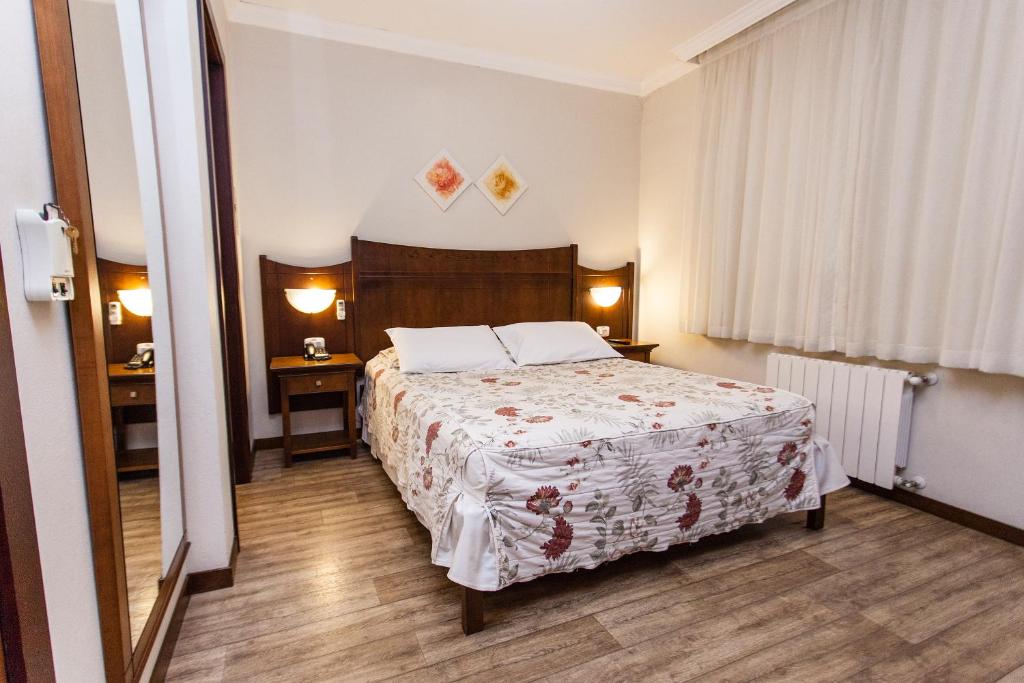 Suíte com cama de casal e mesas de cabeceira em hotéis em gramado pet friendly.