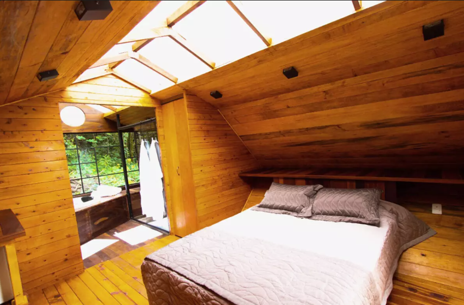 Quarto de madeira integrado com a área de hidromassagem e teto de vidro