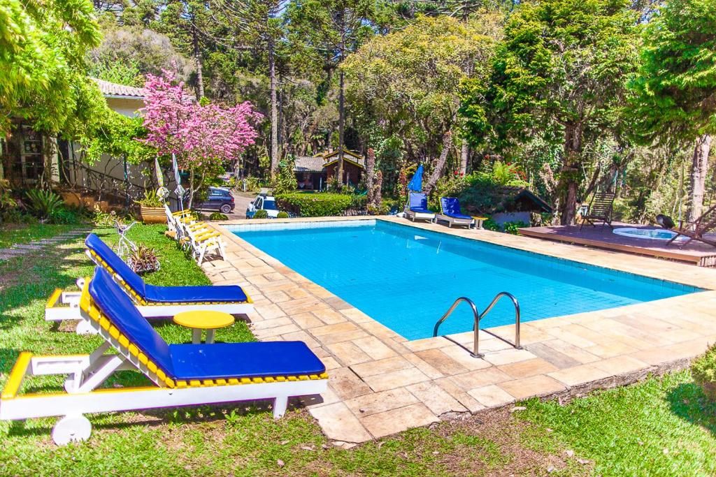 Piscina ao ar livre, abraçado por árvore e um belo jardim, em chalés românticos em Monte Verde.