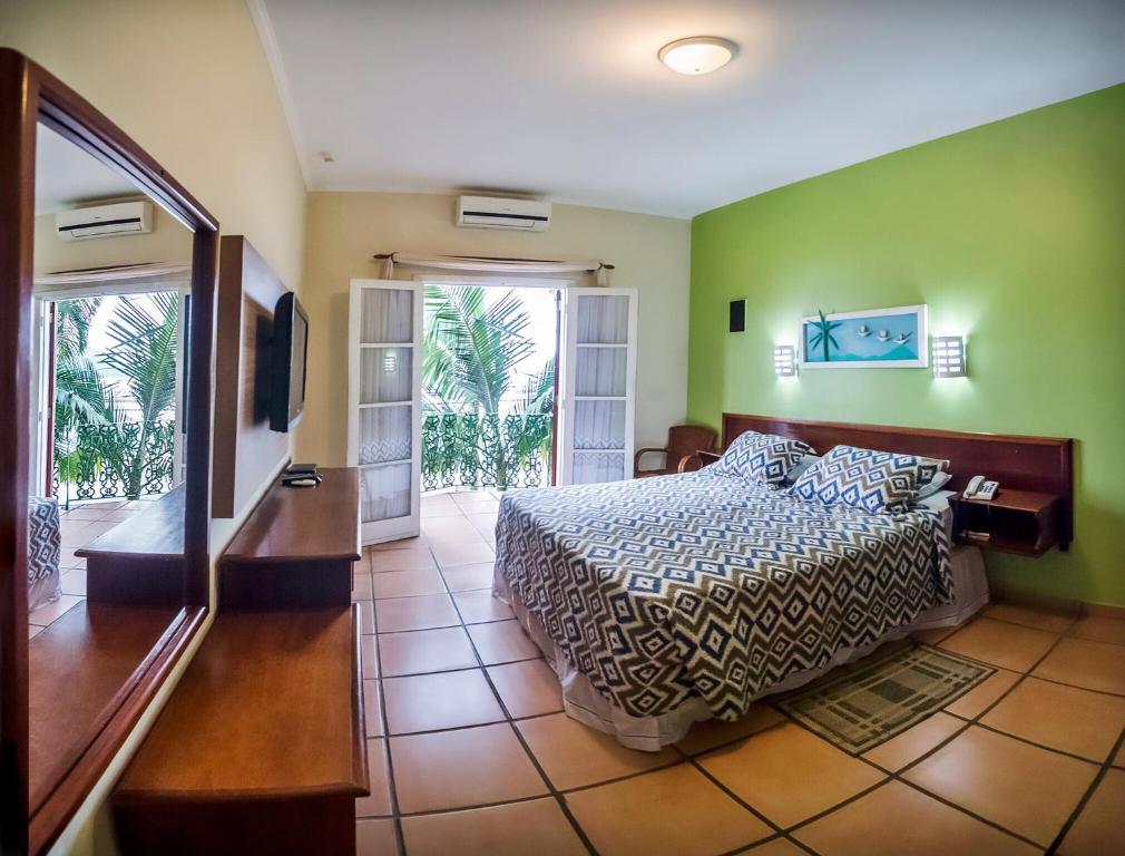 Quarto de casal com vista para a piscina e varanda.