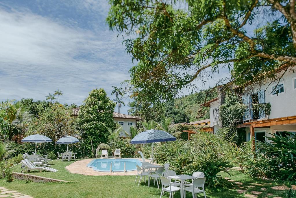 Piscina ao ar livre, no jardim, rodeada por muita natureza