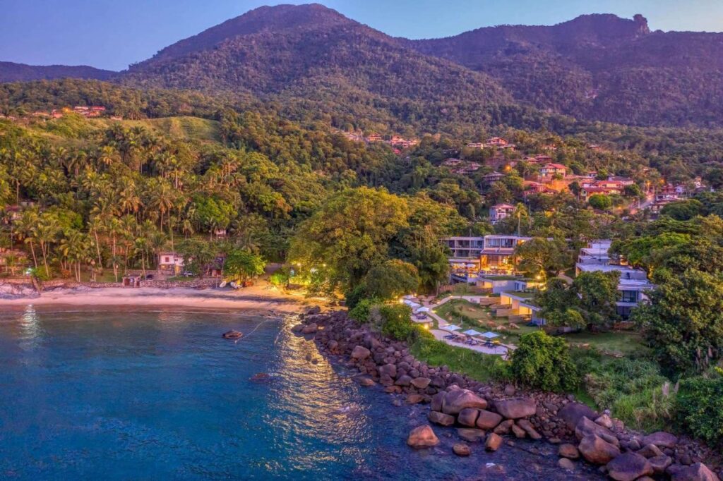 Vista aérea do Wyndham Ilhabela Casa Di Sirena, com praia ao lado e extensa área verde.