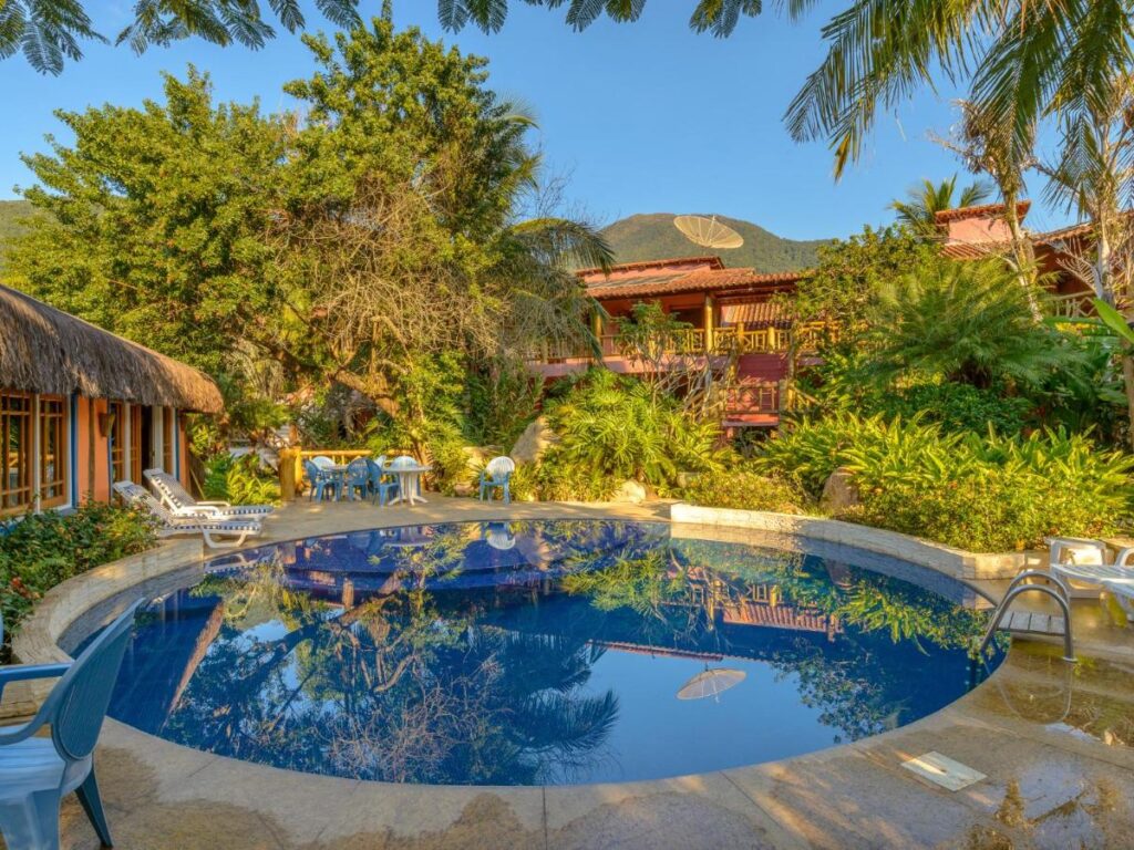 Piscina ao ar livre, rodeada por árvores, em hotéis boutique Ilhabela