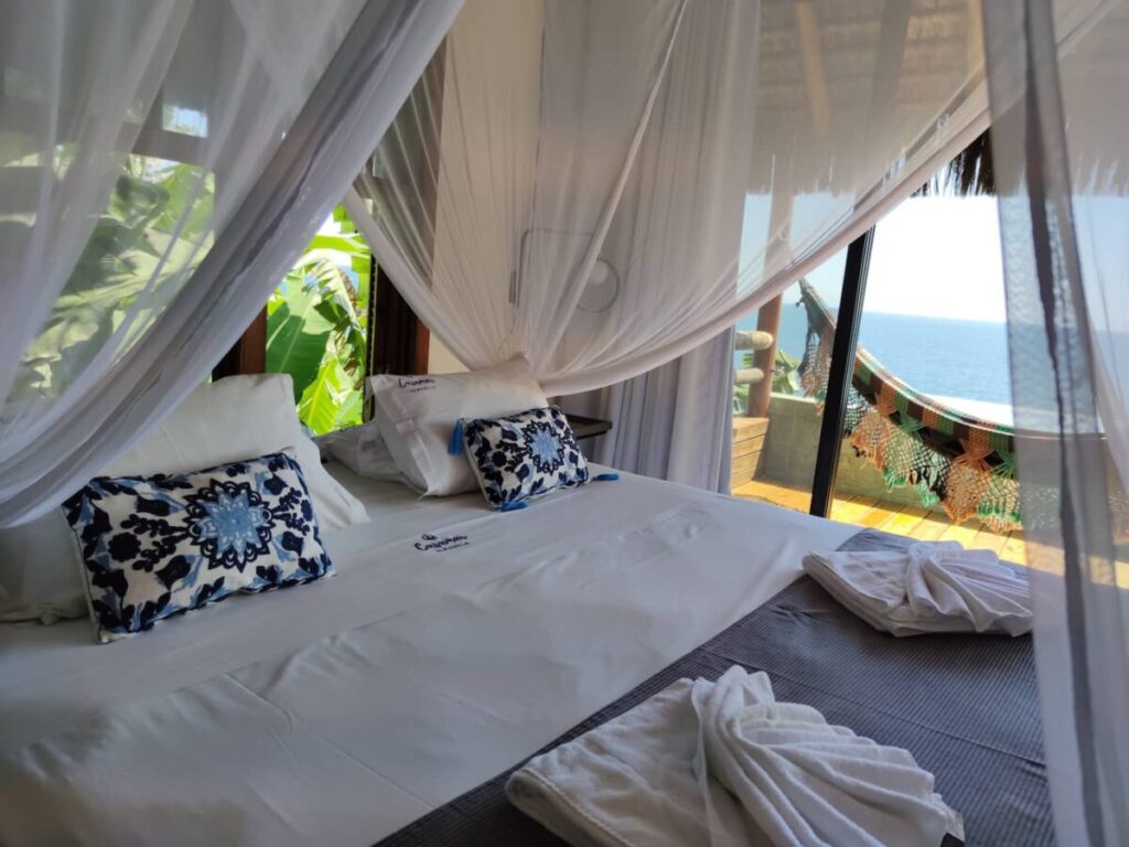 quarto com cama king size e varanda com rede e vista do mar em Ilhabela