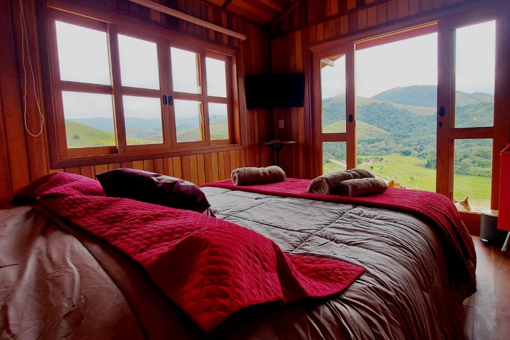 Quarto com cama queen e vista para as montanhas em pousadas românticas interior SP