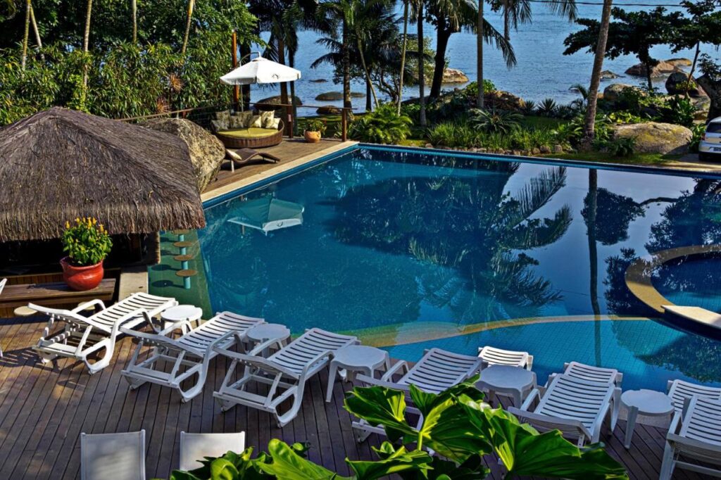 Piscina ao ar livre, de borda infinita com espreguiçadeira em hotéis de luxo Ilhabela