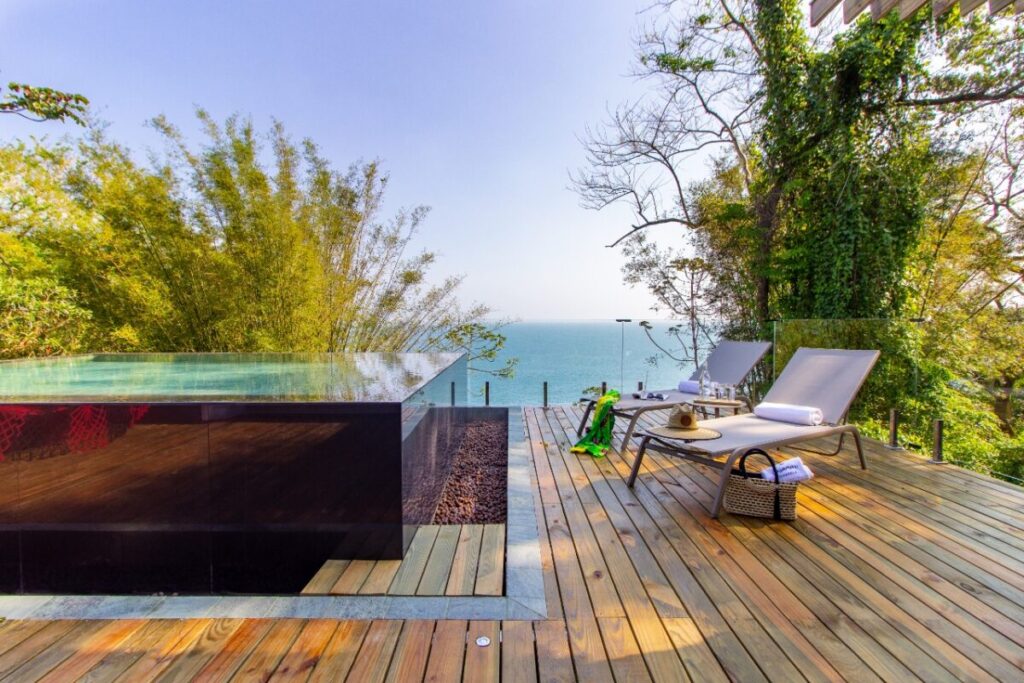 Deck de madeira com piscina e vista para o mar em hotéis de luxo Ilhabela