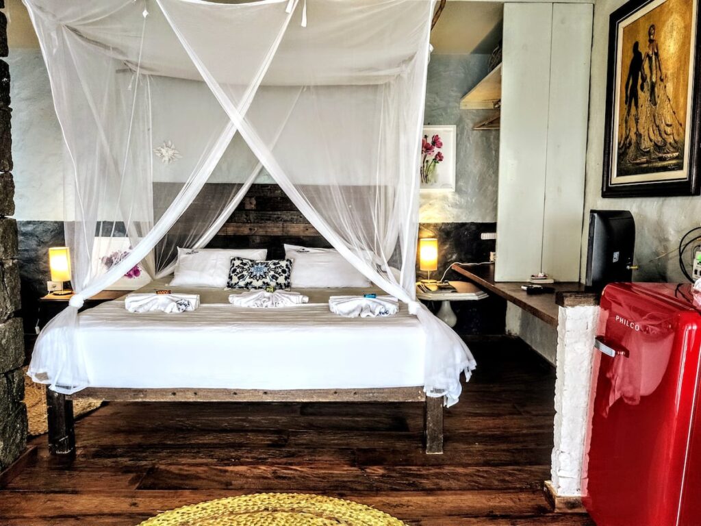 Quarto com cama king, mosquiteiro e frigobar em hotéis de luxo Ilhabela