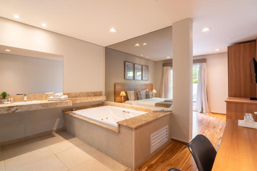 Pousada Grandchamp com quarto moderno e banheiro com hidro