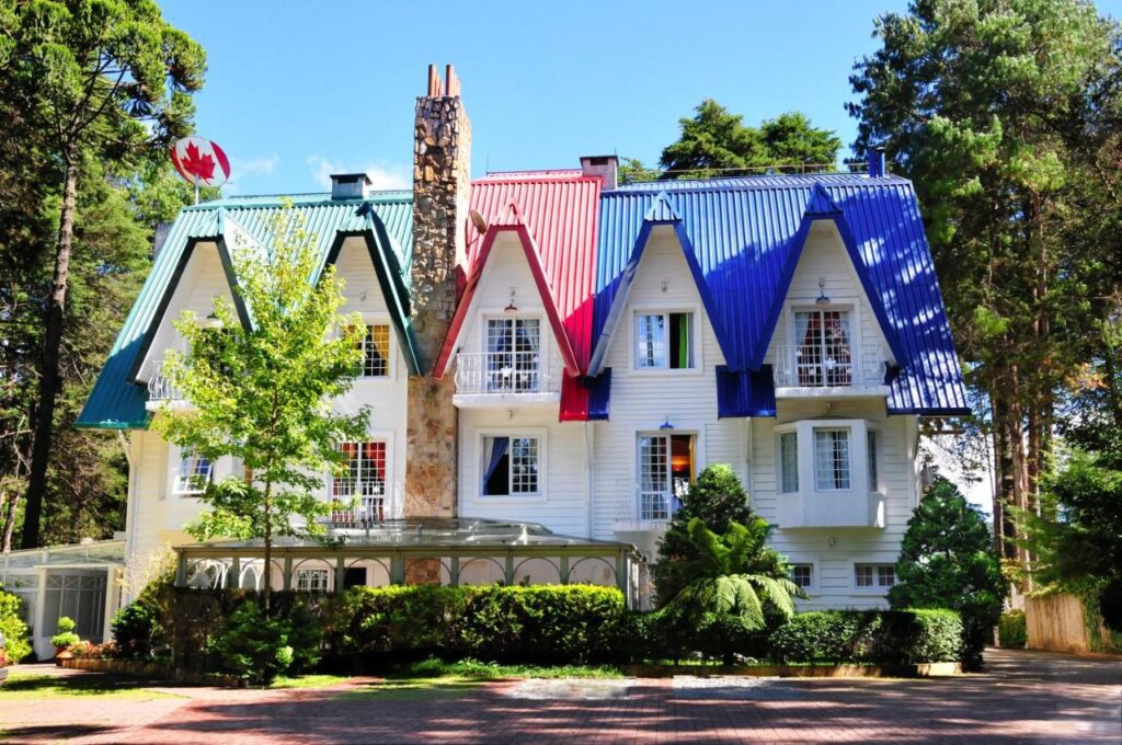 Fachada do Canada Lodge Campos do Jordão, estilo suíço, porém branco e com telhados coloridos