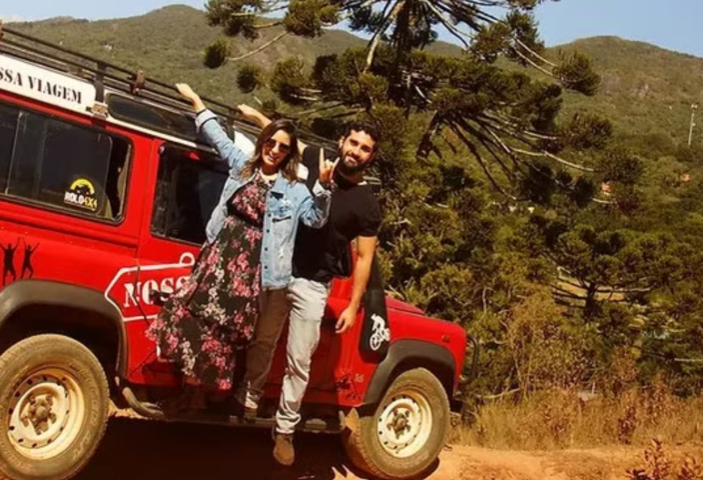 Casal perto de um 4x4 vermelho em uma trilha - Passeio Quadriciclo em Monte Verde