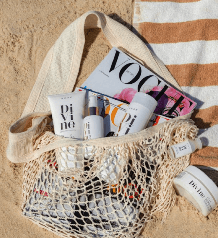 Imagem de produtos BRAÉ numa bolsa na areia de praia.